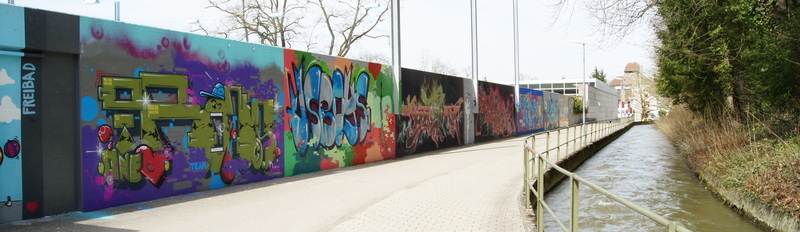 Die Grafitiwand mit ihren verschiedenen Kunstwerken mit Blick Richtung Schlossbadi.